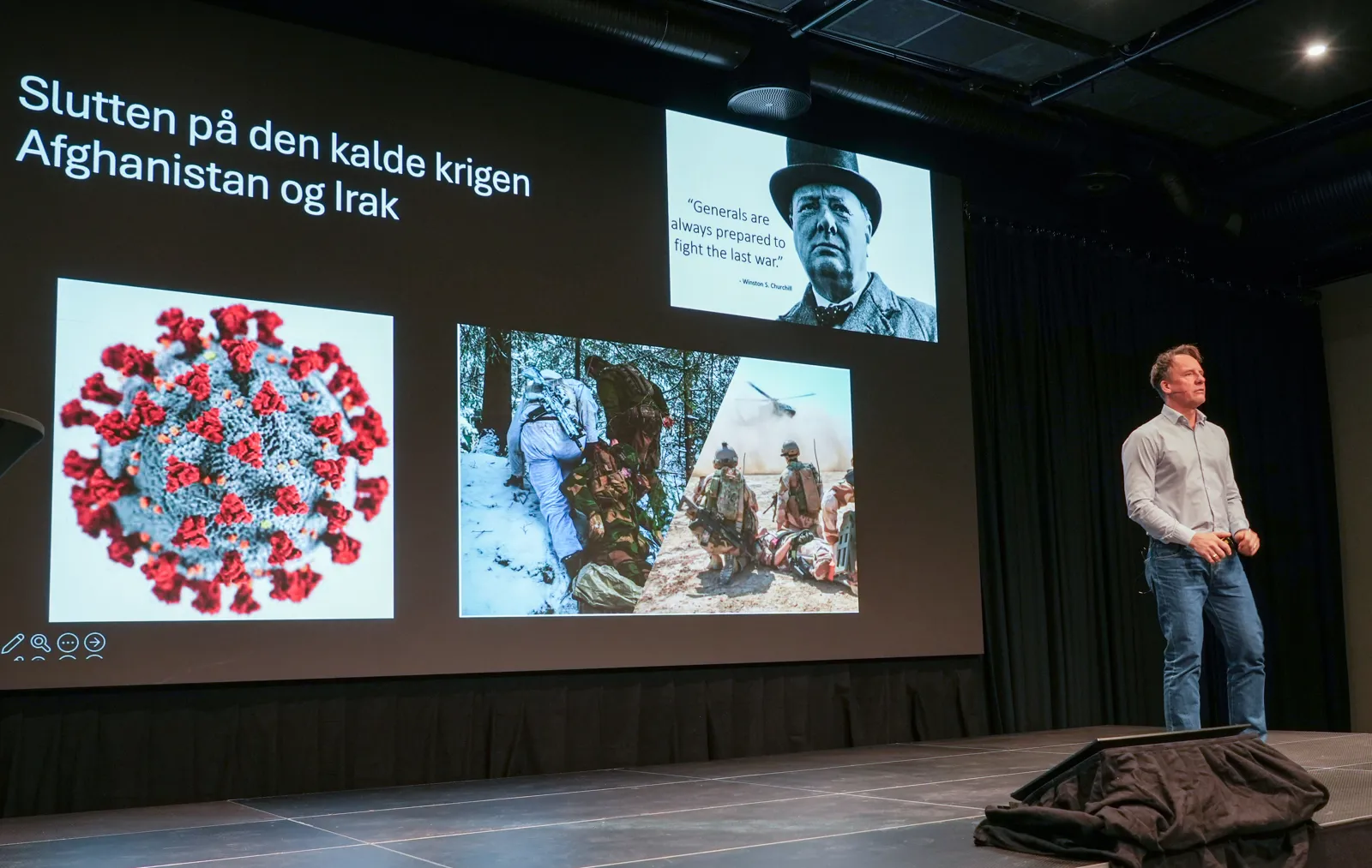 En mann som står ved siden av en stor skjerm