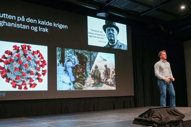 En mann som står ved siden av en stor skjerm