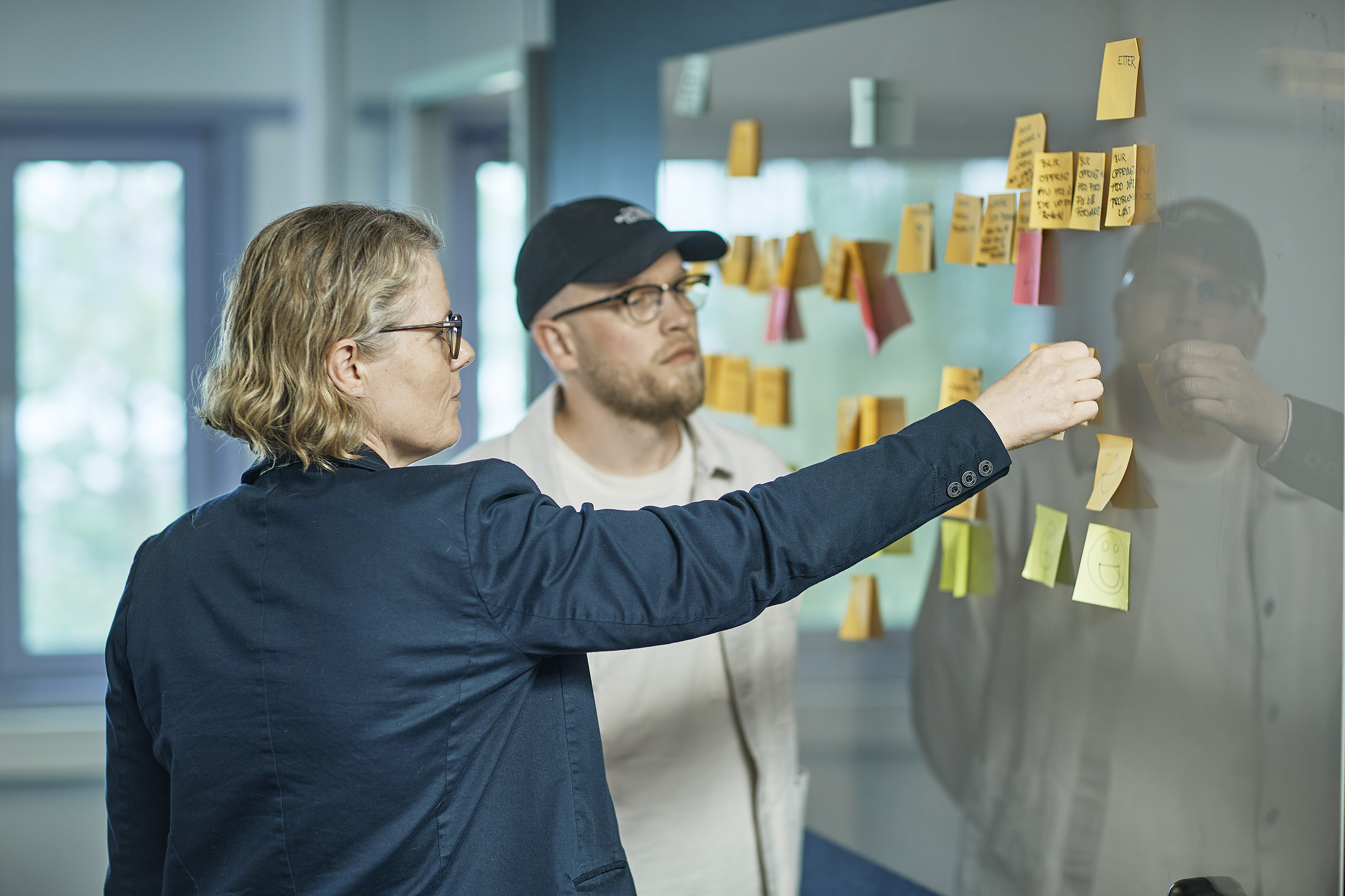 En dame og en mann som jobber med post-it lapper