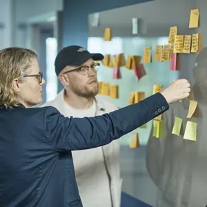 En dame og en mann som jobber med post-it lapper