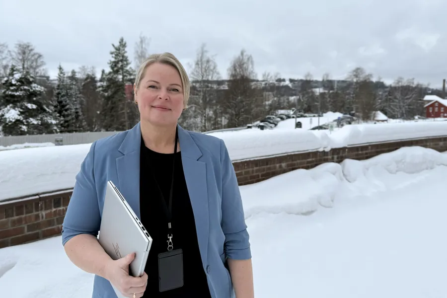 Et portrettbilde av en kvinne som holder en bærbar PC