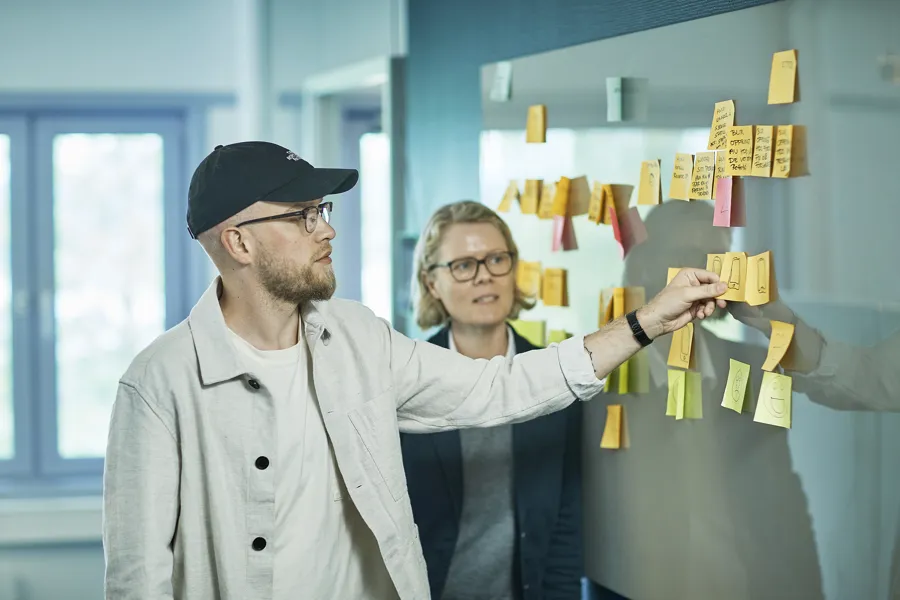 Bilde av to mennesker som kommuniserer med gule lapper