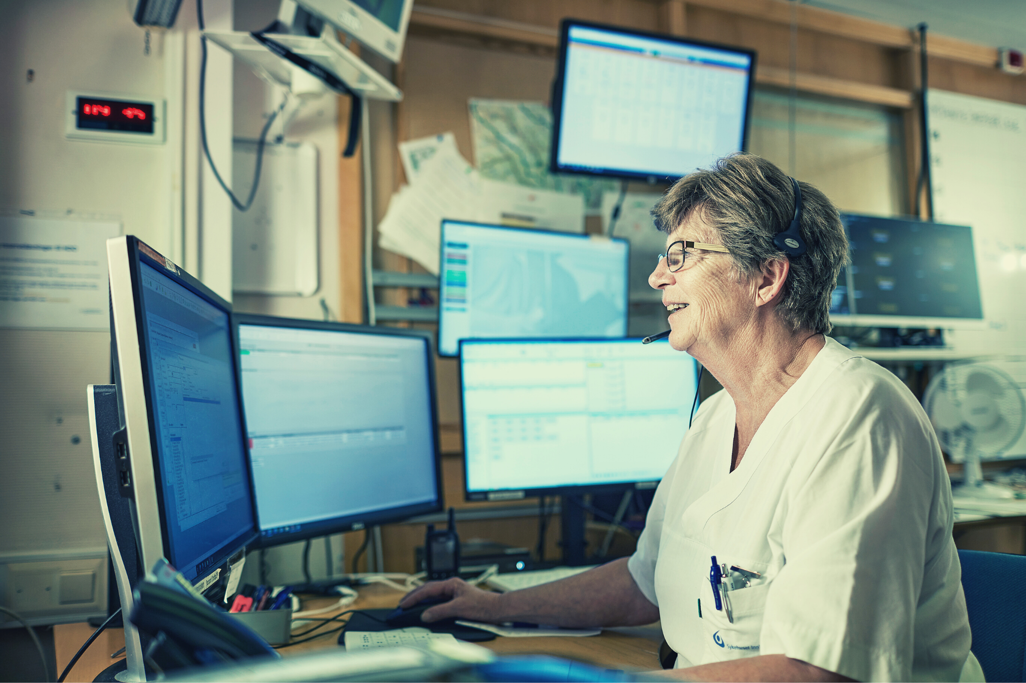 En mann som sitter ved et skrivebord med en datamaskin