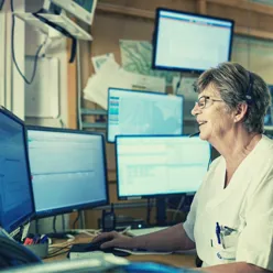 En mann som sitter ved et skrivebord med en datamaskin