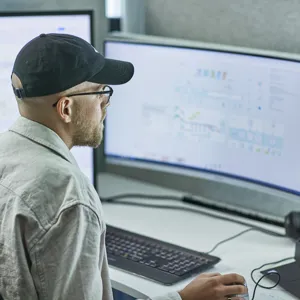 Bilde av en mann som ser på pc-skjermer