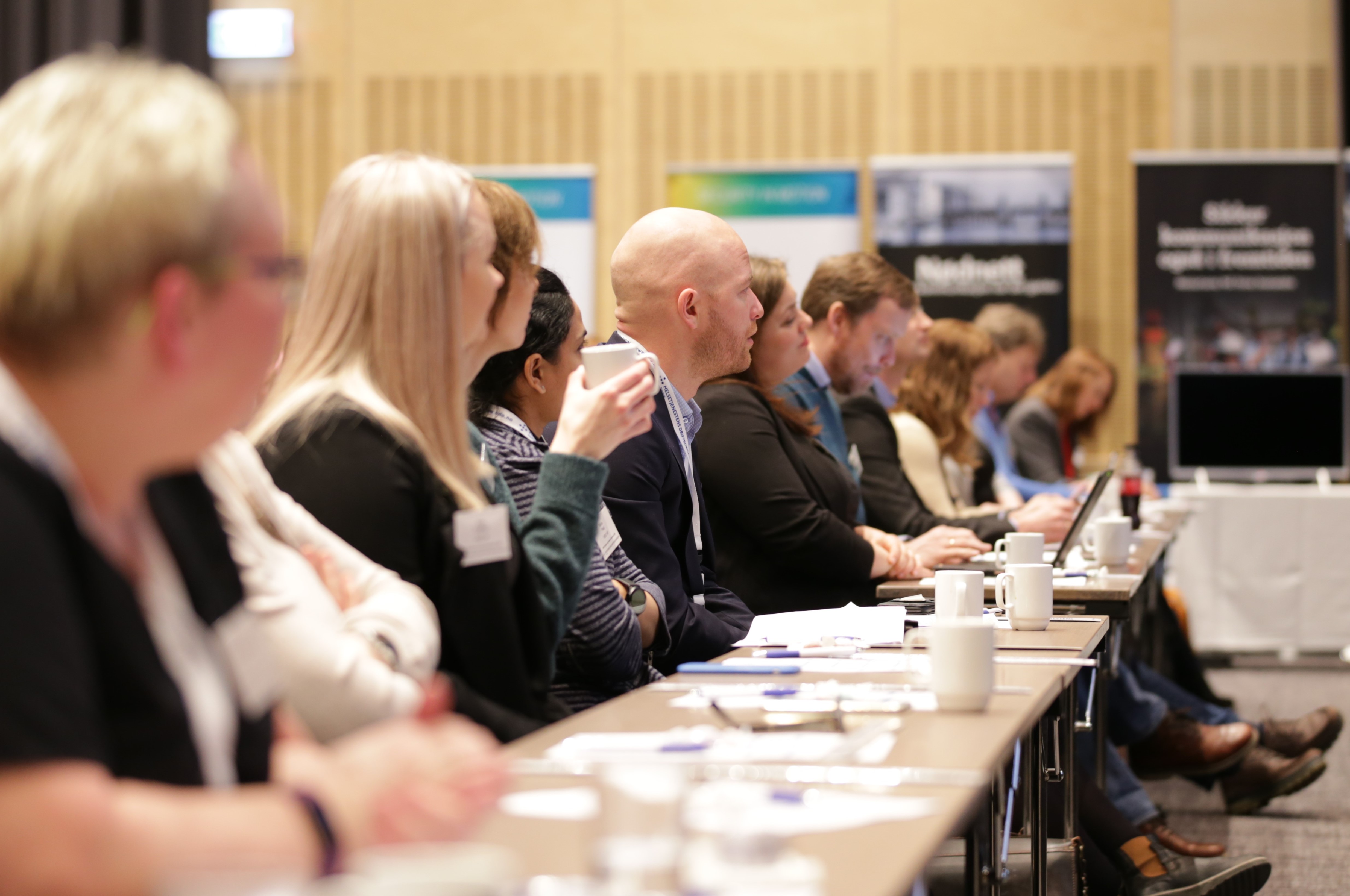 Bilde av en rekke mennesker som følger med på noe foran seg