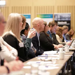 Bilde av en rekke mennesker som følger med på noe foran seg