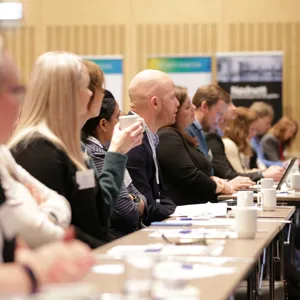 Bilde av en rekke mennesker som følger med på noe foran seg