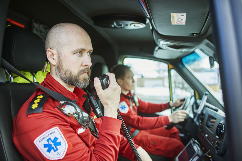 Ambulansearbeider som snakker i bilmontert radio