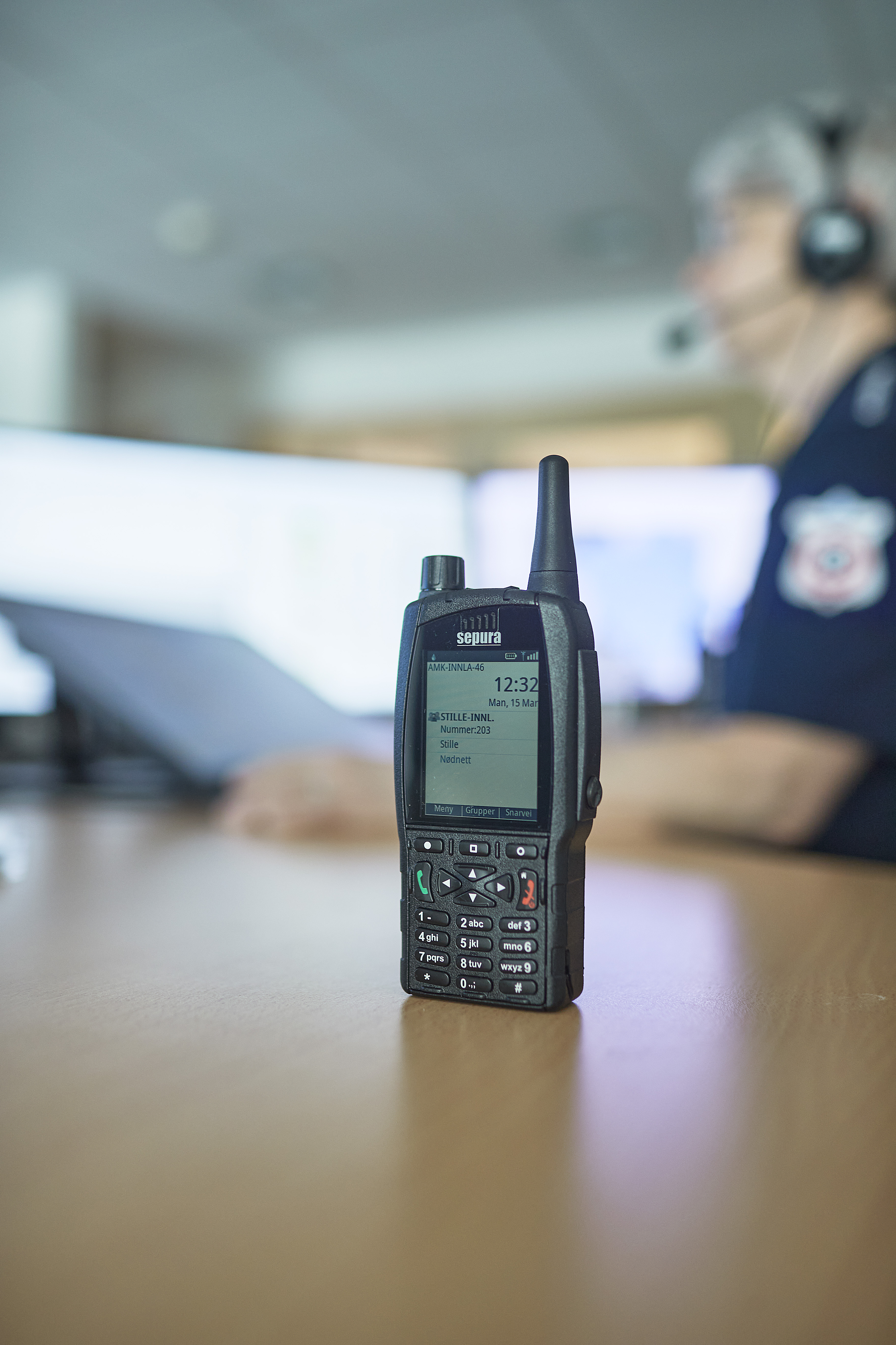 A close-up of a handheld radio communication device lying on a table.