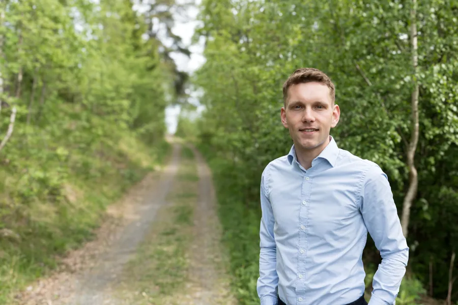 En mann som står på en grusvei