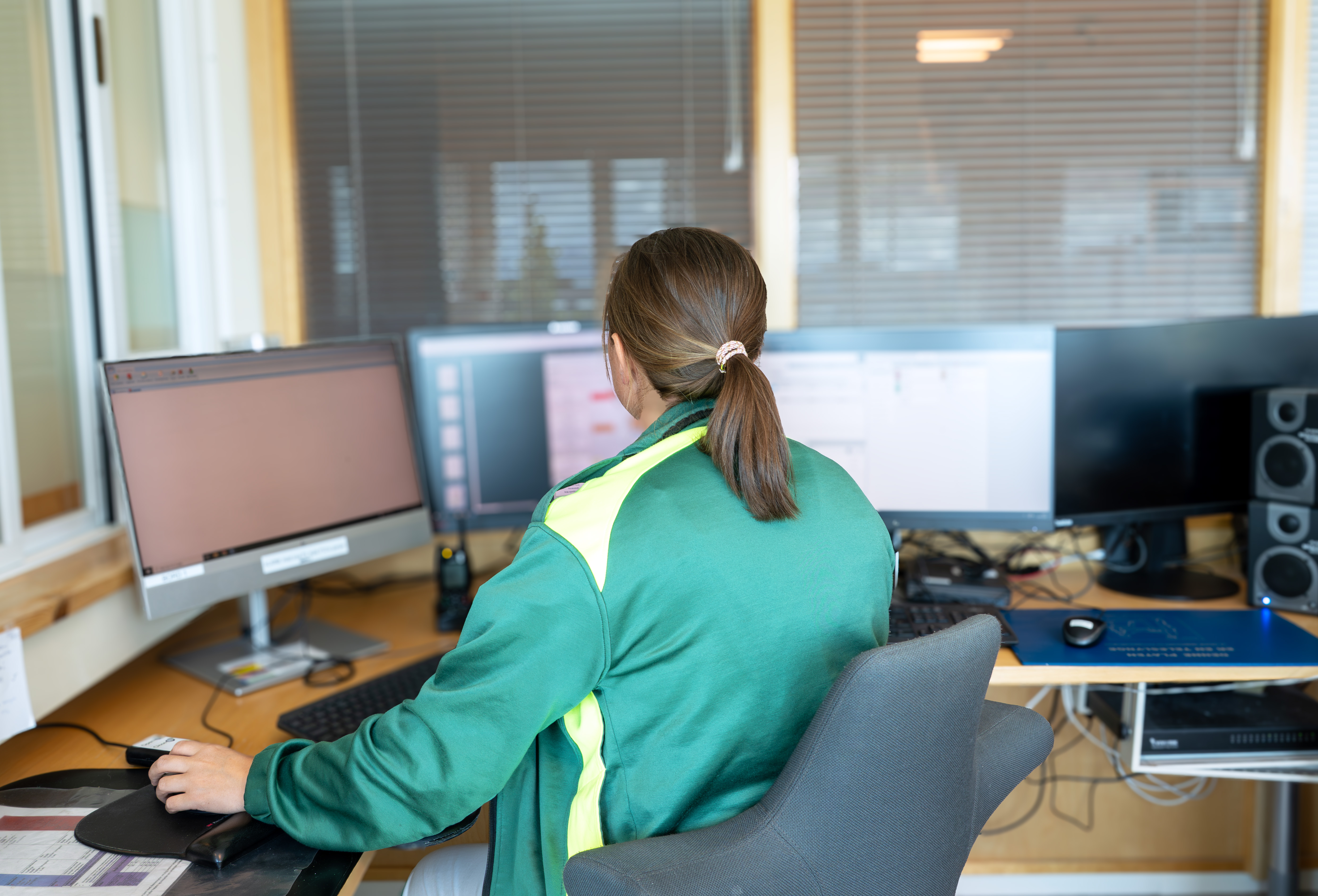 En person som sitter ved et skrivebord med en datamaskin