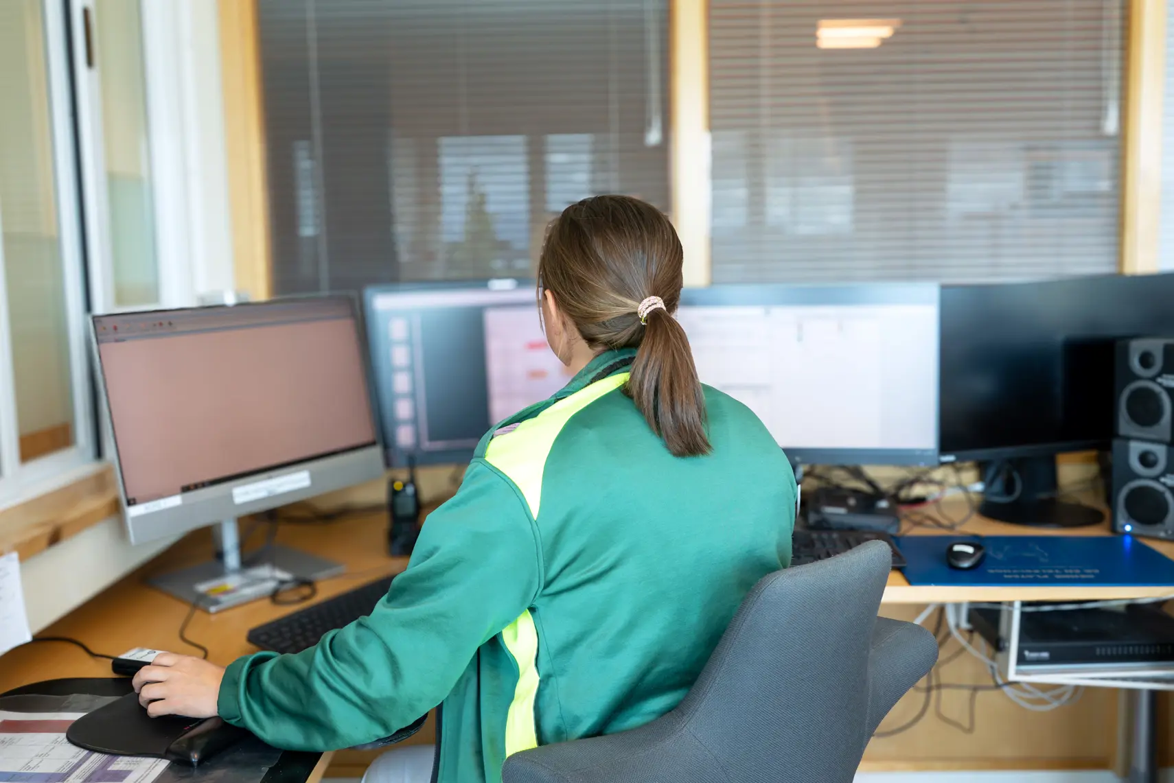 En person som sitter ved et skrivebord med en datamaskin