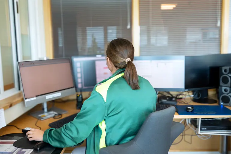 En person som sitter ved et skrivebord med en datamaskin