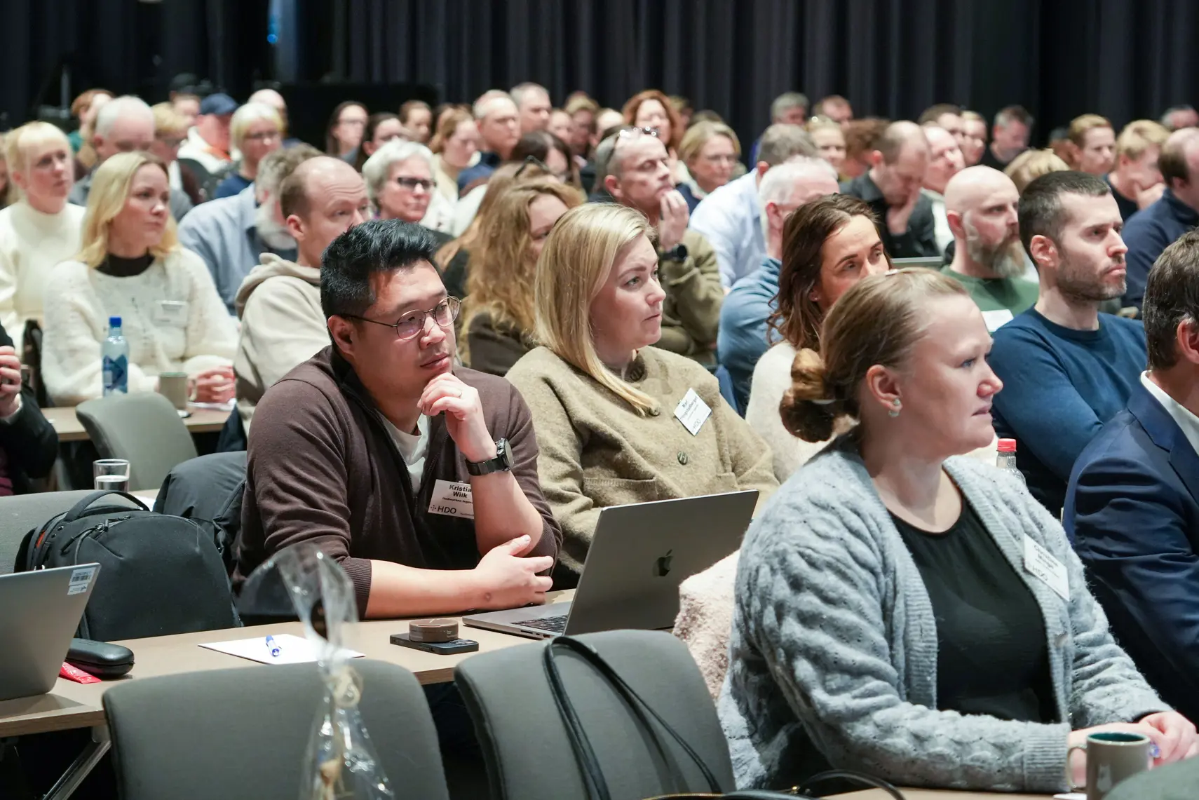 En gruppe mennesker som sitter i et rom med bærbare datamaskiner