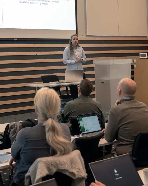 En person som holder en presentasjon for en gruppe mennesker