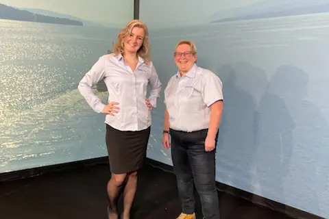 To kvinnelige ansatte i HDO smiler mot kamera